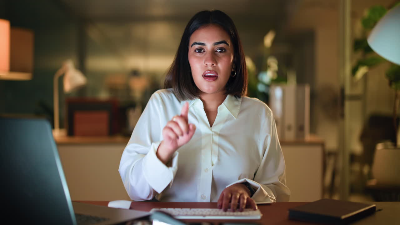 Woman working on laptop in office at night