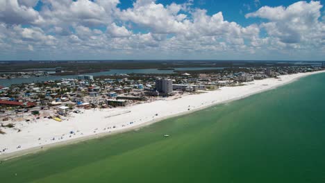 Drone-shot-panning-to-the-left-of-Fort-Myers-Beach,-Florida-with-tourists