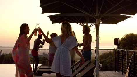 happy diverse friends with drinks dancing at pool party in slow motion