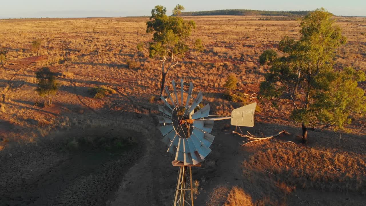 Mulino a vento al tramonto nell'outback di Emerald, Queensland, Australia
