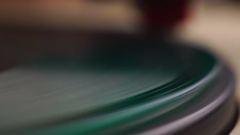 macro close up, green vinyl record spinning on vintage gramophone