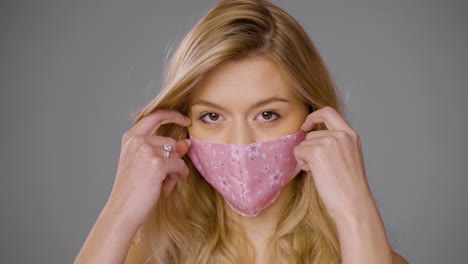 vrouw die een roze bloemenmasker aanpast