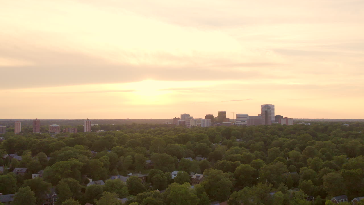 나무 위로 일몰 때 클레이튼 스카이라인에서 천천히 뒤로 물러나십시오.