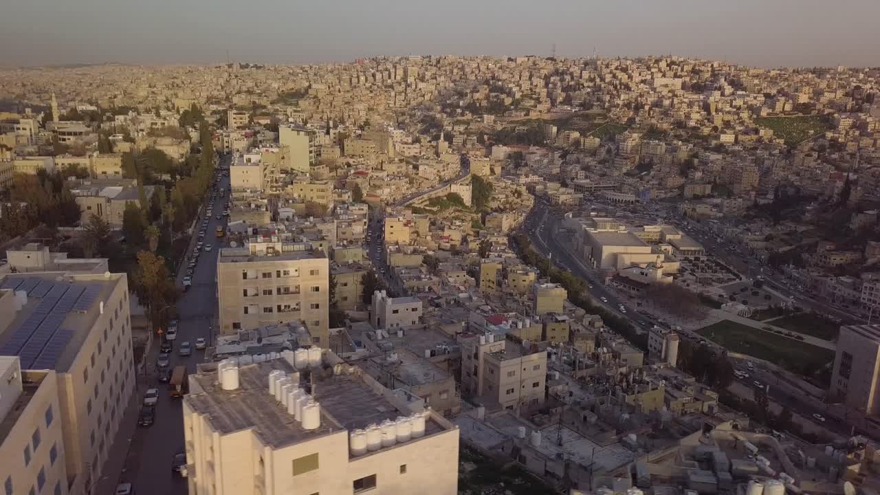 Giornata nuvolosa ad Amman, Giordania, con la luce del sole che filtra per una bellissima ripresa aerea della città mentre il traffico scorre senza intoppi