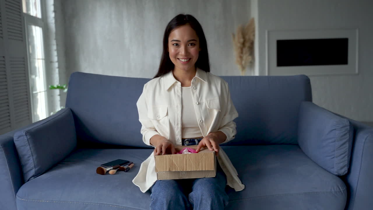 influenciadora femenina haciendo unboxing, mostrando nuevos pinceles de maquillaje