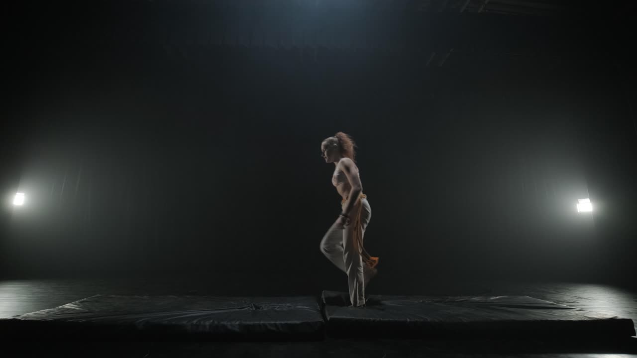 Lottatori di Capoeira che eseguono mosse dinamiche sul palco. Arti marziali, danza e acrobazie in azione. Atleti a torso nudo che mostrano forza, flessibilità e tecnica sotto i riflettori