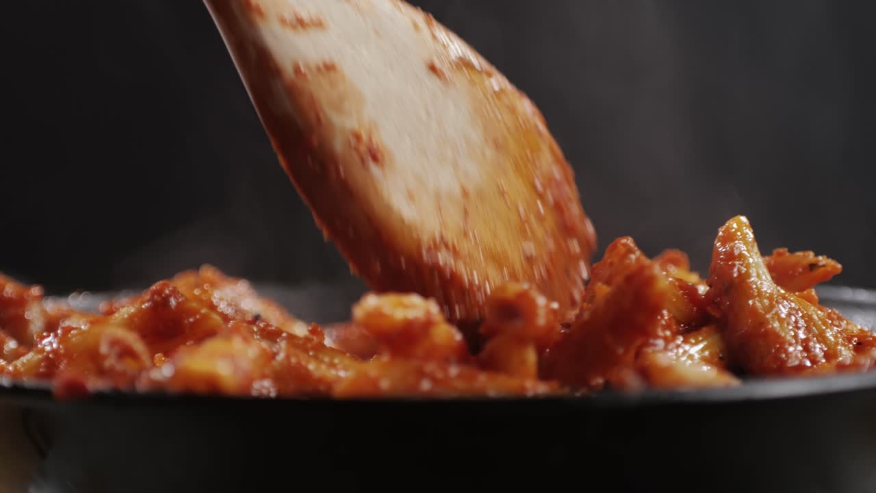 Cooking traditional arrabbiata pasta, penne with tomato sauce close-up. Cook classic homemade Italian tomato sauce for pasta and pizza in the pan. Chef cooks traditional Italian food. High quality 4k footage