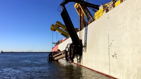 una toma estática de una draga de succión con cortador en el trabajo de recuperación de tierras para nuevos puertos colocados en puntas como anclas y descarga del suelo dragado a través de una tubería flotante