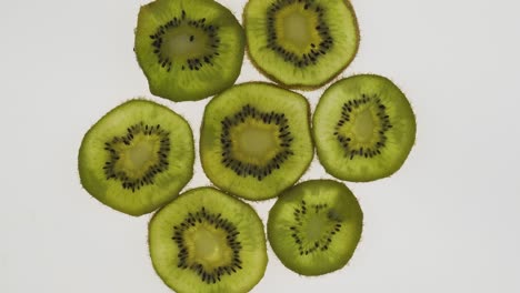 colección de rebanadas de kiwi frescas sobre un fondo blanco. fruta cítrica de rotación. vista superior.