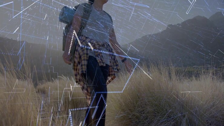 Vertical video: Walking hiker carrying pack and mat at ridge base, camera moving overlay increasing