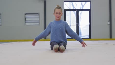 teenage female gymnast performing at sports hall