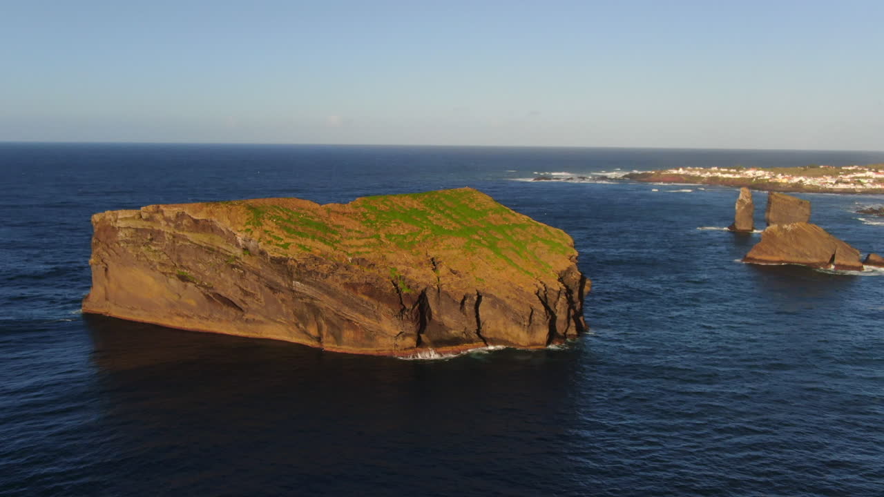 пляж мостеирос на острове сан-мигель: воздушный вид на орбите над большим скальным образованием возле пляжа