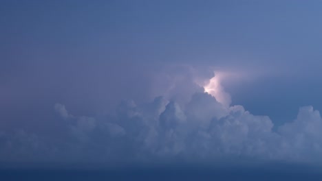 lightning flashes lighting up stormy night clouds