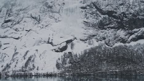 White snow avalanche from high rocky mountain in Norway, handheld view