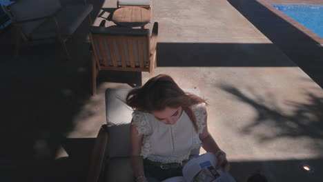 young woman drinking coffee and reading with outdoors at the poo area, slow motion