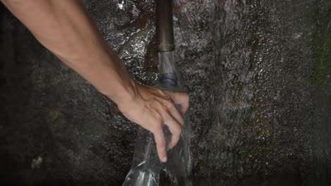 persona llenando una botella de agua potable de un manantial natural no tratado en bejís