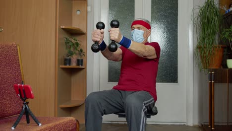 Senior-elderly-caucasian-man-making-weightlifting-dumbbells-exercising-at-home-during-coronavirus