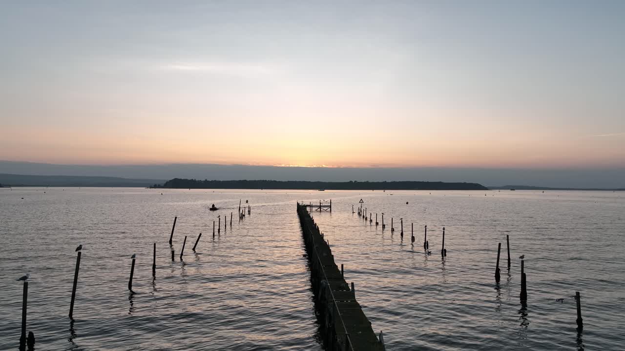 bournemouth, reino unido - volando desde los muelles más allá de las gaviotas con un hombre amarrando su barco