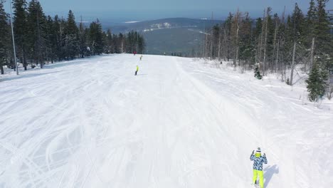 snowy mountain ski slope with people skiing and snowboarding