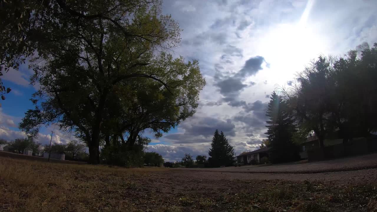 timelapse - nubes que viajan frente al sol con vistas a una calle vacía en un pequeño pueblo cerca de alberta canada en un buen día