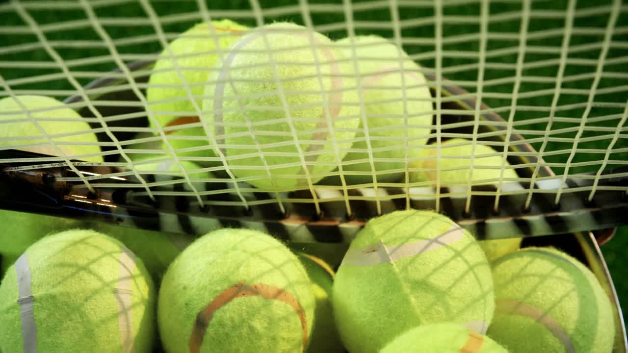Tennisbälle und Schläger im Eimer im Studio 4K