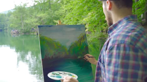 painter paints landscape in nature.