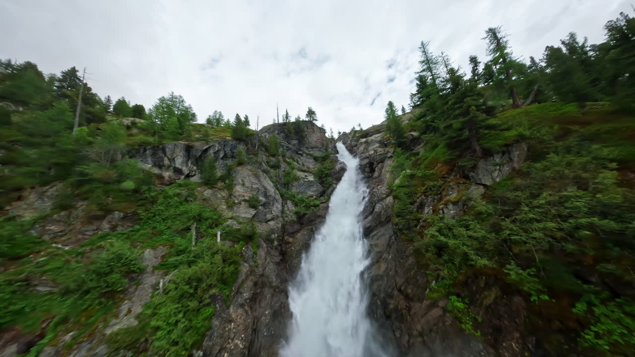 una impresionante cascada que cae en cascada por una exuberante ladera verde de la montaña en un entorno natural sereno
