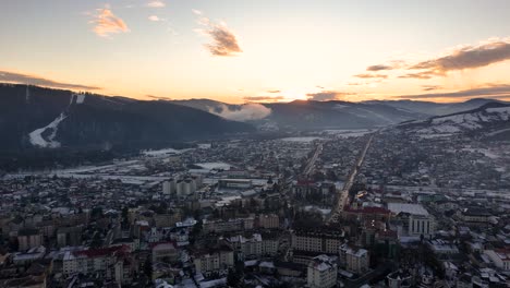 imágenes de drones de un paisaje urbano nevado de gura humorului, destacando la escénica ladera de partia soimul y una impresionante puesta de sol