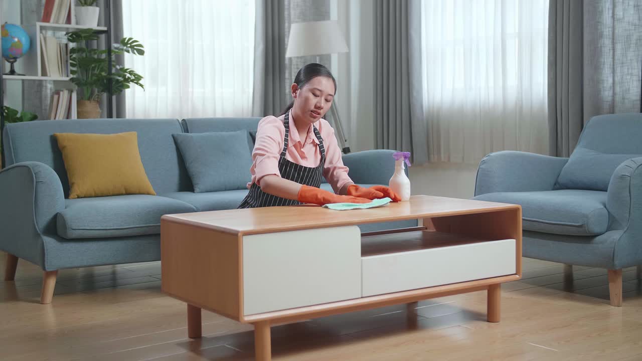 여성이 거실을 청소하고 허리 통증을 경험하고 있습니다.