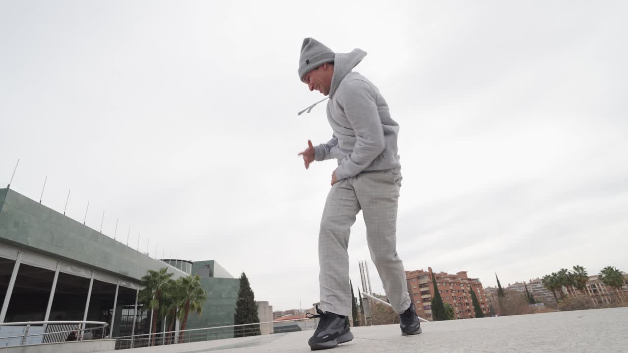 Energetic male dancer performing urban freestyle moves outdoors