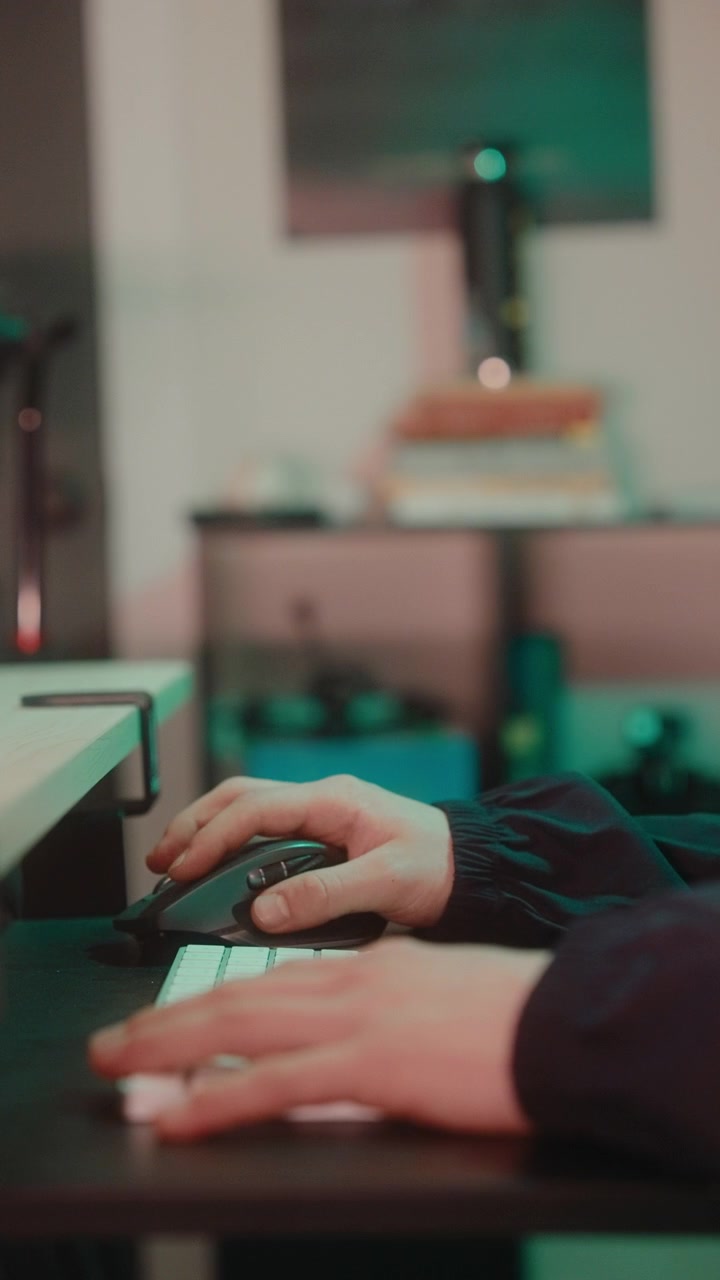 Primo piano di mani che digitano su una tastiera di computer e usano un mouse wireless in un ufficio moderno.