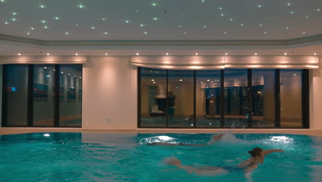 man and woman swimming in the indoor pool