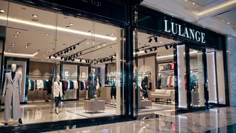 Wide-angle shot of a luxury clothing store interior, showcasing elegant suits and modern decor