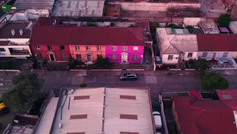 Recorrido-Aéreo-De-Una-Calle-Con-Casas-Idénticas-Una-Al-Lado-De-La-Otra,-Colores-Brillantes-En-Un-Barrio-Tranquilo