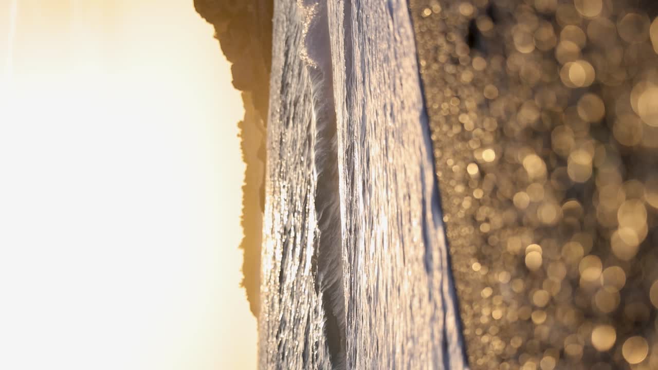 olas en cámara lenta en una playa rocosa durante la puesta de sol