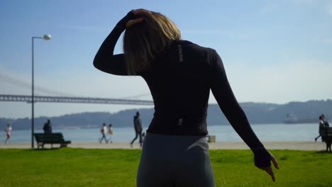 vista posterior de una chica deportiva estirándose al aire libre