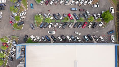 drone arriba hacia abajo descendiendo en los coches dando vueltas en un estacionamiento lleno de gente