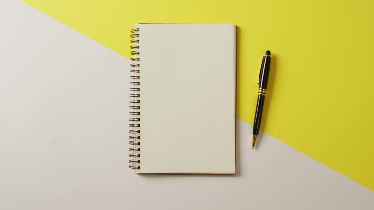 Video of notebook with copy space and pencil on yellow background
