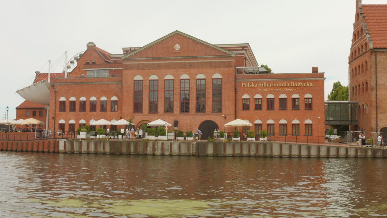 The Polish Baltic Philharmonic building in Gdansk, along the Motlawa River with outdoor cafes