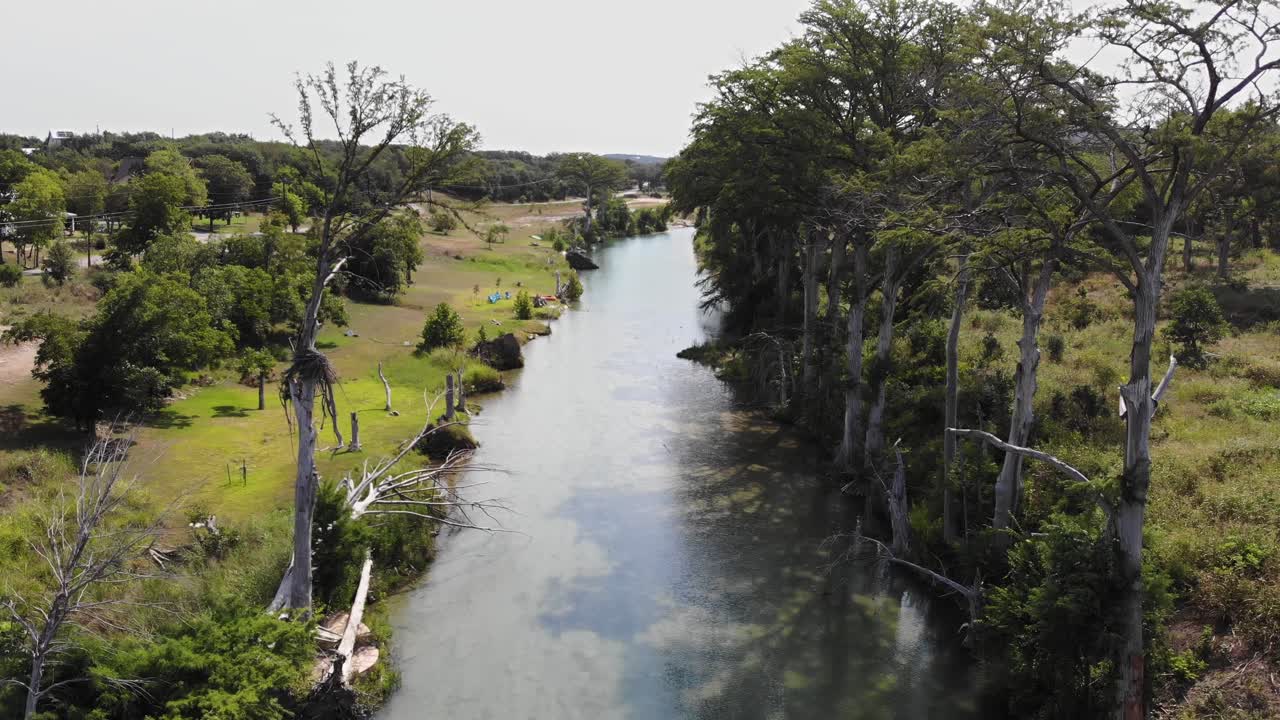 elevándose sobre el río con un impresionante conjunto de cipreses en el lado derecho y un árbol solitario en el izquierdo