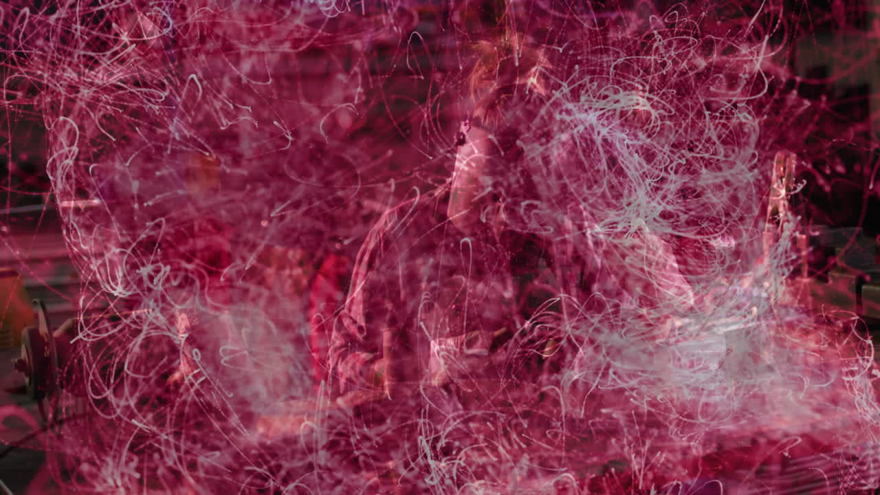 Woman welding metal with torch in industrial workshop, showing swirling red and white light trails