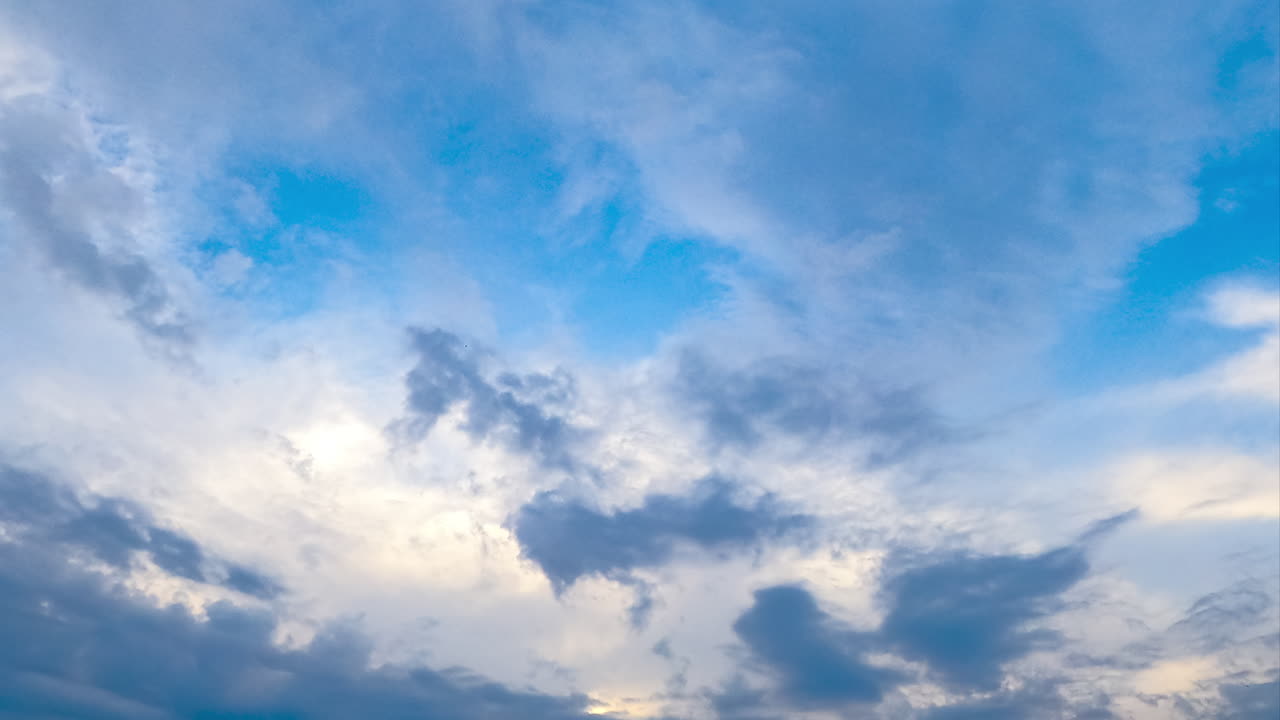 Amazing light clouds appearing in the sky. Timelapse of quick cloud transformation. Low angle view.