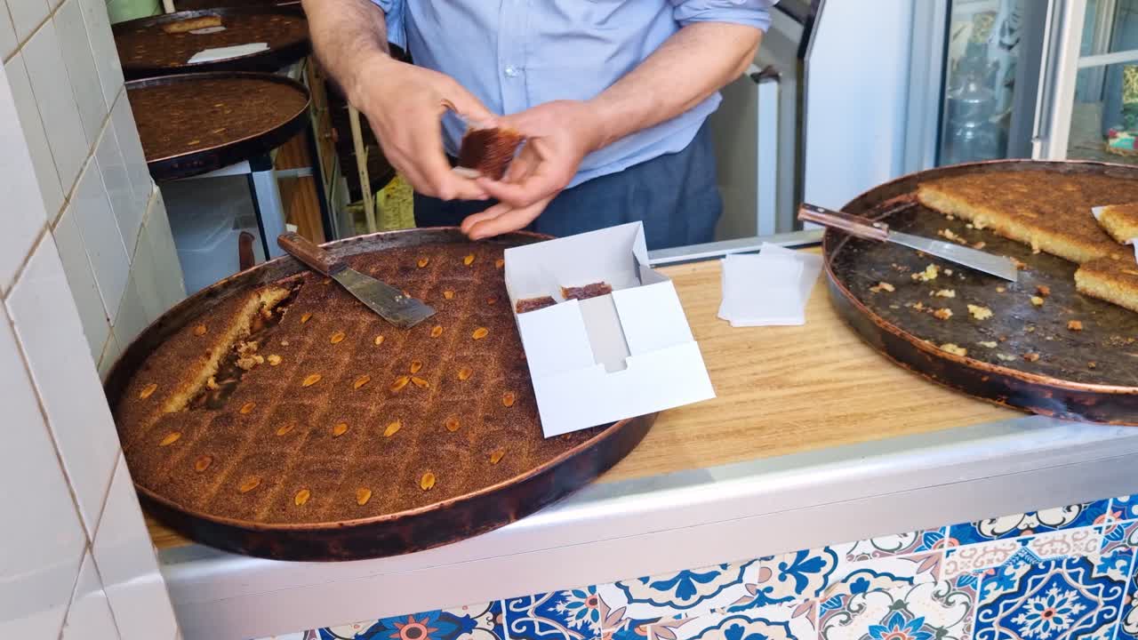 Man preparing and serving delicious baklava in a bakery
