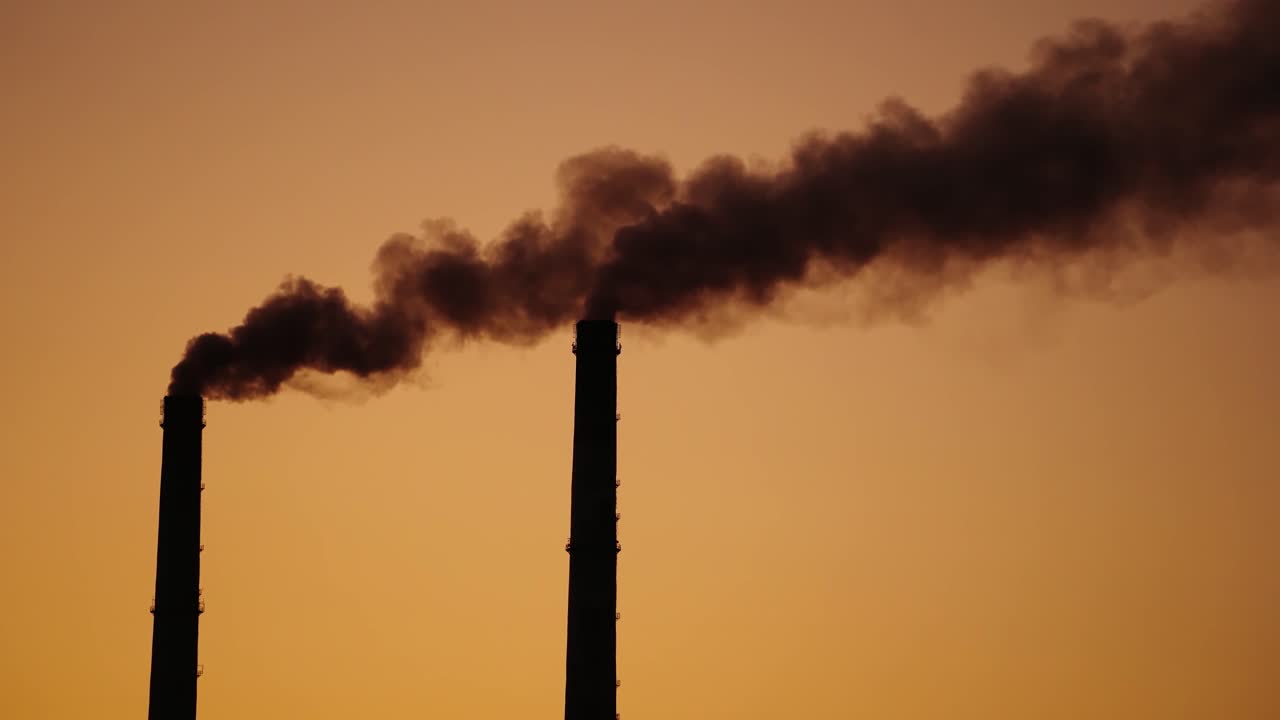 The steaming tube or pipe of the plant, factory or thermal power station on the background of dark sky. Monochrome video.