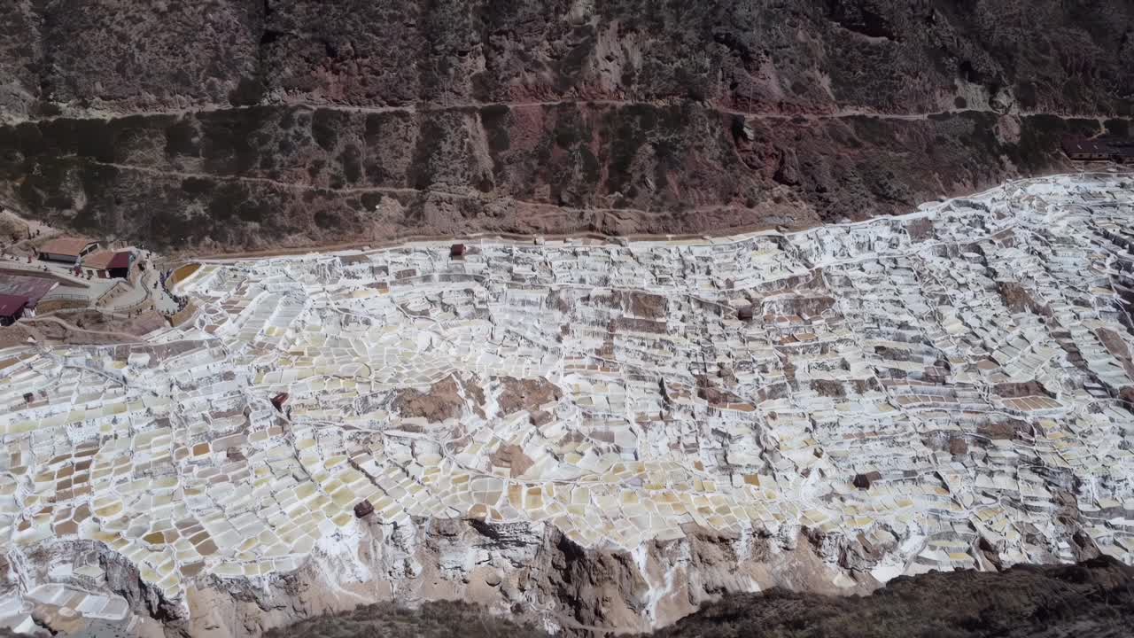 Wide aerial showcasing the intricate geometric salt pools of Salineras de Maras