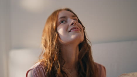 closeup dreamy girl holding smartphone in bedroom. smiling teenager get message