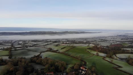 aerial panning left shot of the river otter valley in devon england on a frosty misty morning