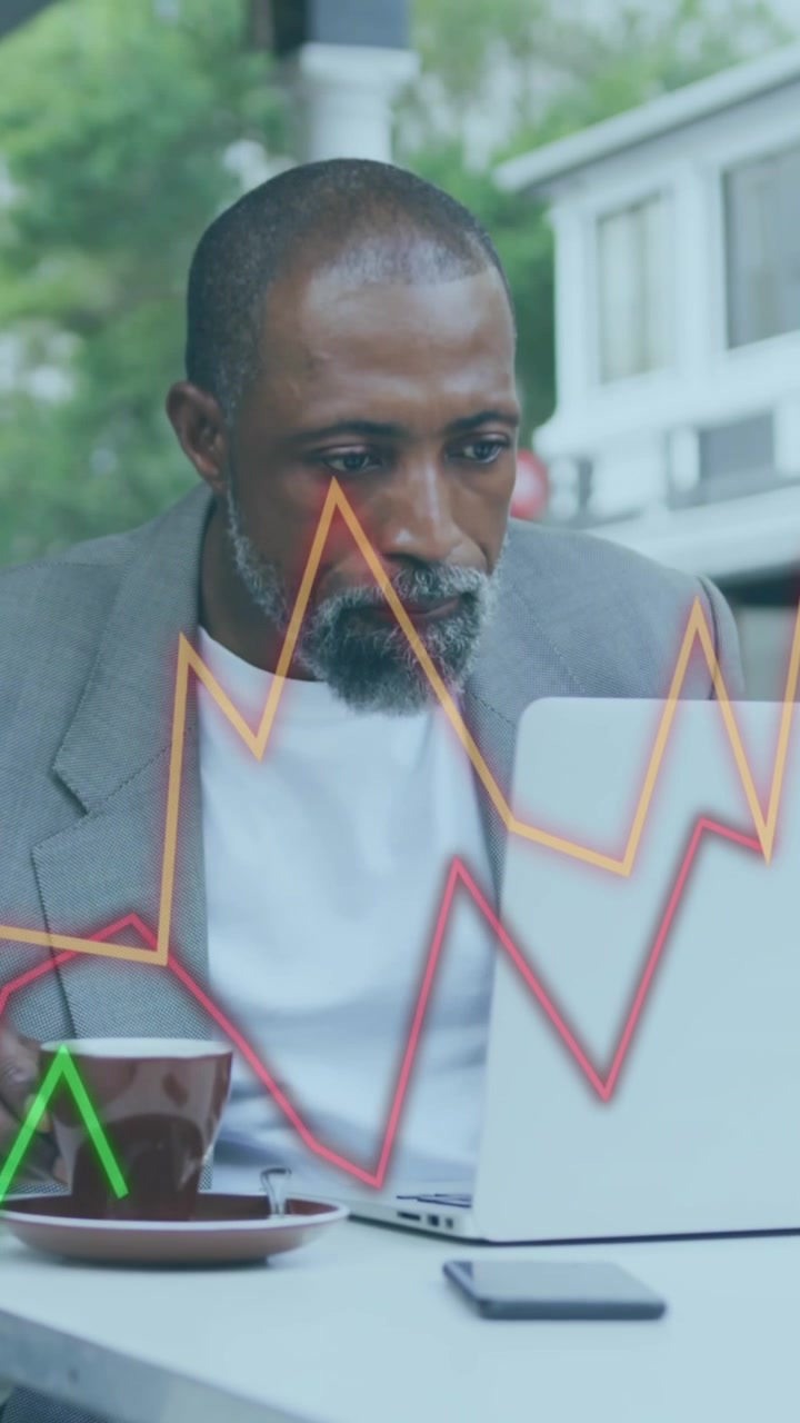 Animation of financial data processing over african american businessman using laptop