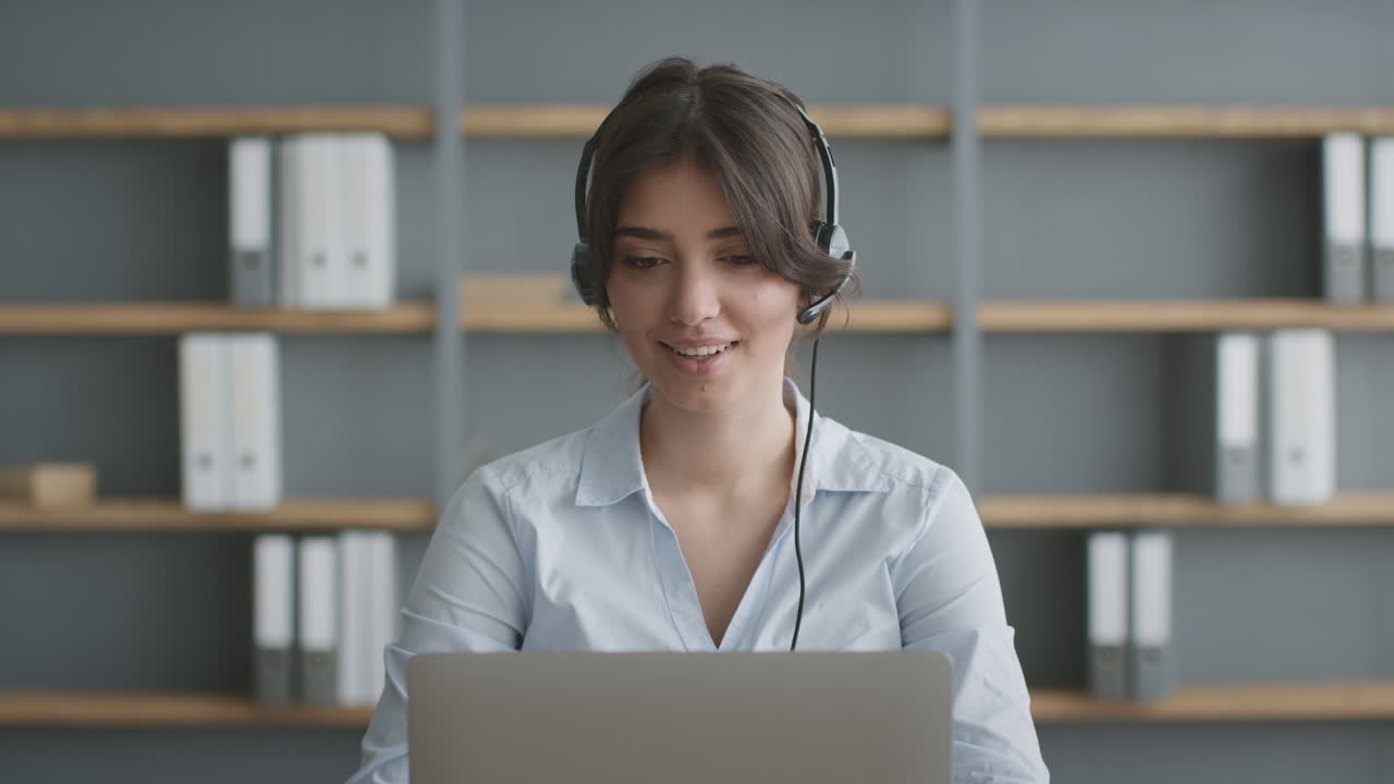 mujer trabajando en una computadora portátil con auriculares