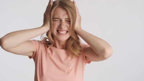 una mujer caucásica cubriéndose las orejas ante la cámara.